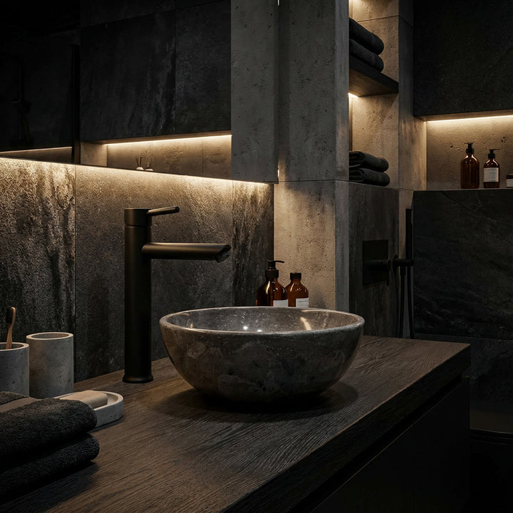 Rundes Aufsatzwaschbecken aus Marmor auf dunklem Holzwaschtisch im modernen Spa-Badezimmer mit schwarzer Armatur und indirektem Licht
