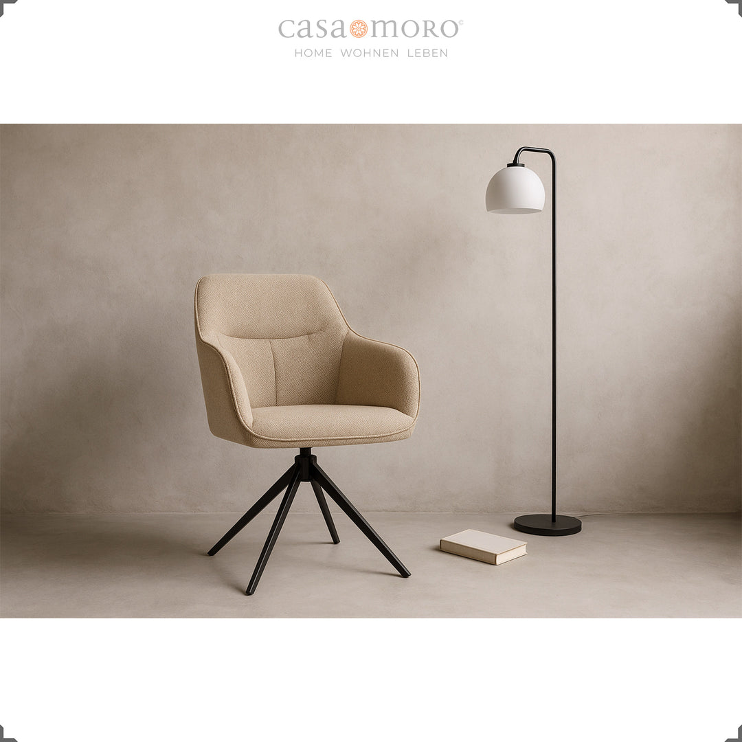 Moderner 360° drehbarer Polsterstuhl mit Armlehnen in Beige, inszeniert im Wohnzimmer mit schwarzer Stehlampe und Buch auf hellem Boden