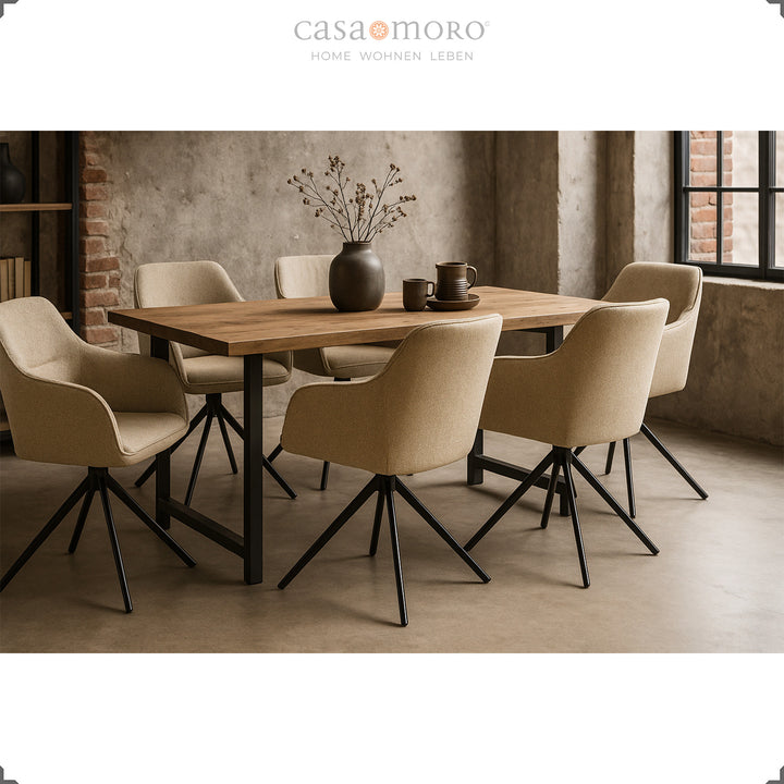 Sechs 360° drehbare Polsterstühle mit Armlehnen in Beige um einen Holztisch in einem modernen Esszimmer mit Betonwänden und schwarzem Metallgestell