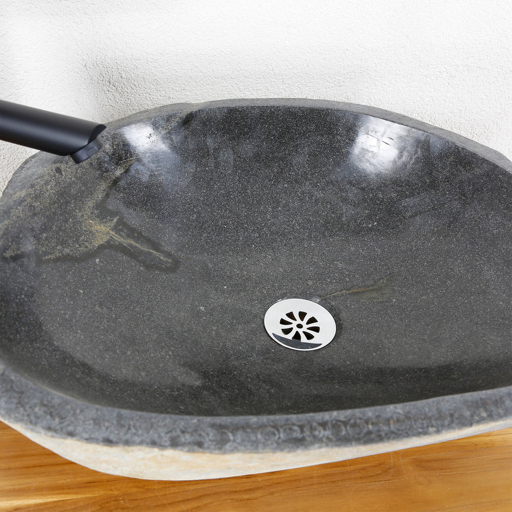 Detailansicht eines Aufsatzbecken aus Stein mit fein polierter Innenfläche, natürlicher Maserung und mittigem Ablauf