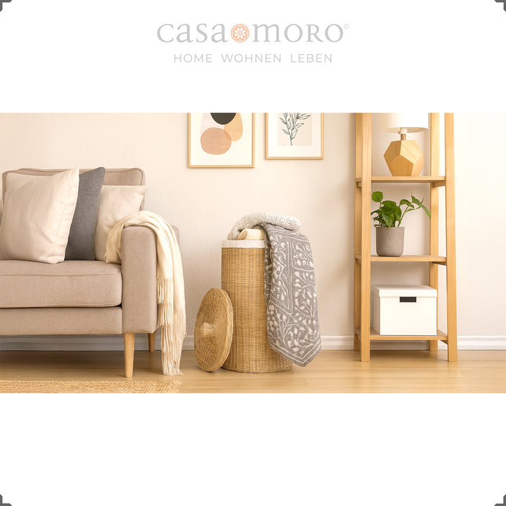 Dekorativer Wäschekorb aus Rattan im Wohnzimmer, kombiniert mit Wohntextilien und Naturtönen